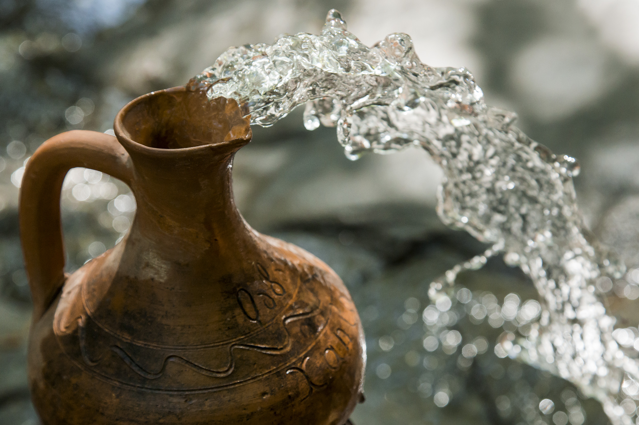 Water flows from a ceramic jug 