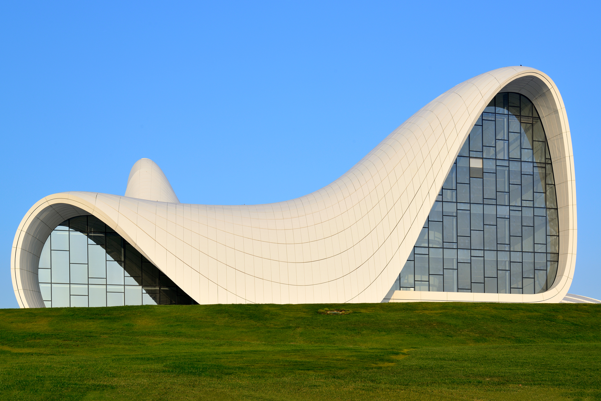 A curved building with grass in front of it