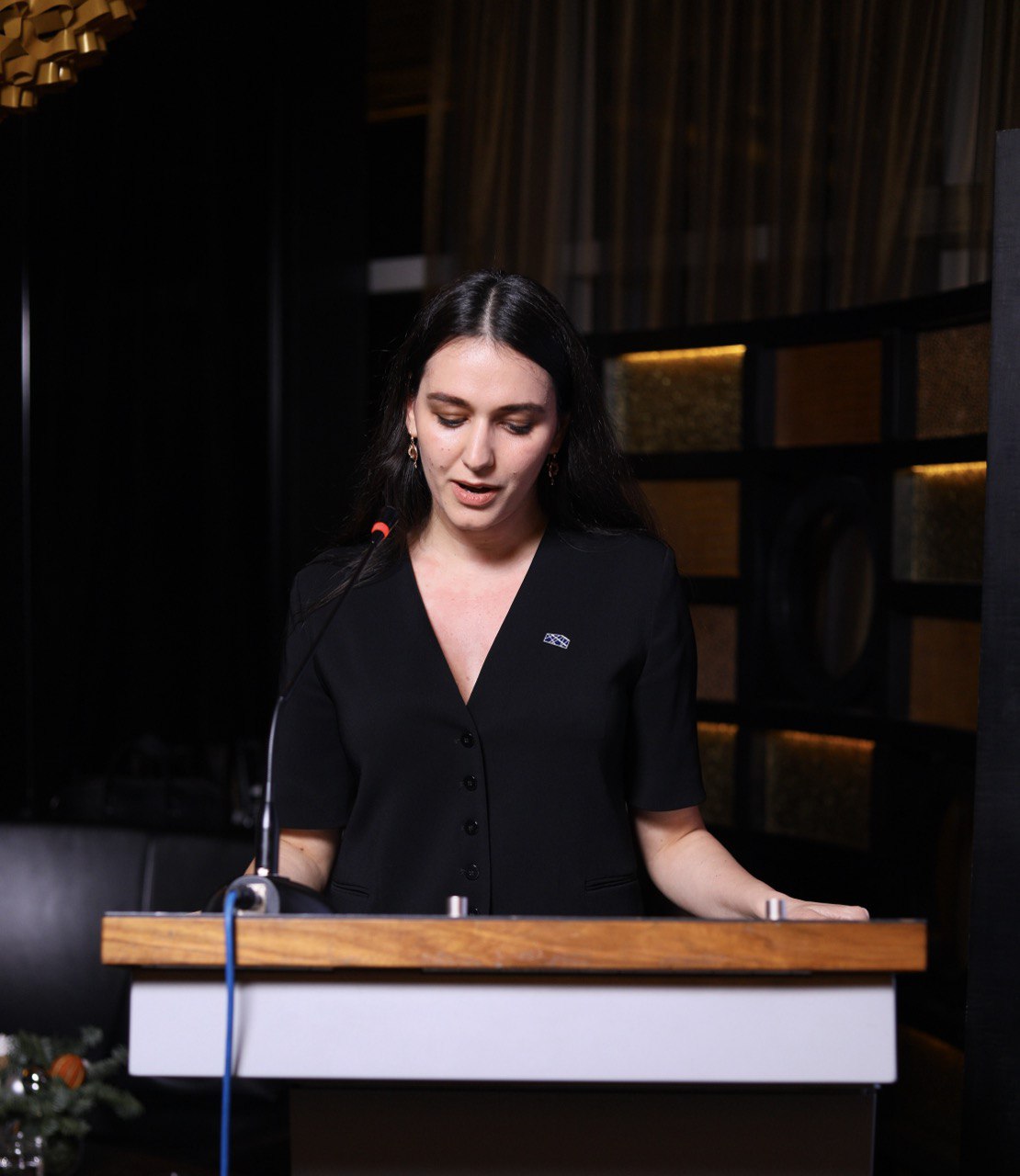 A woman standing at a podium making a speech