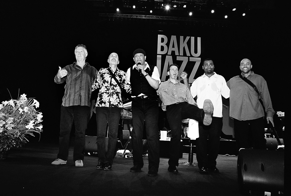 A group of men singing and dancing on a stage