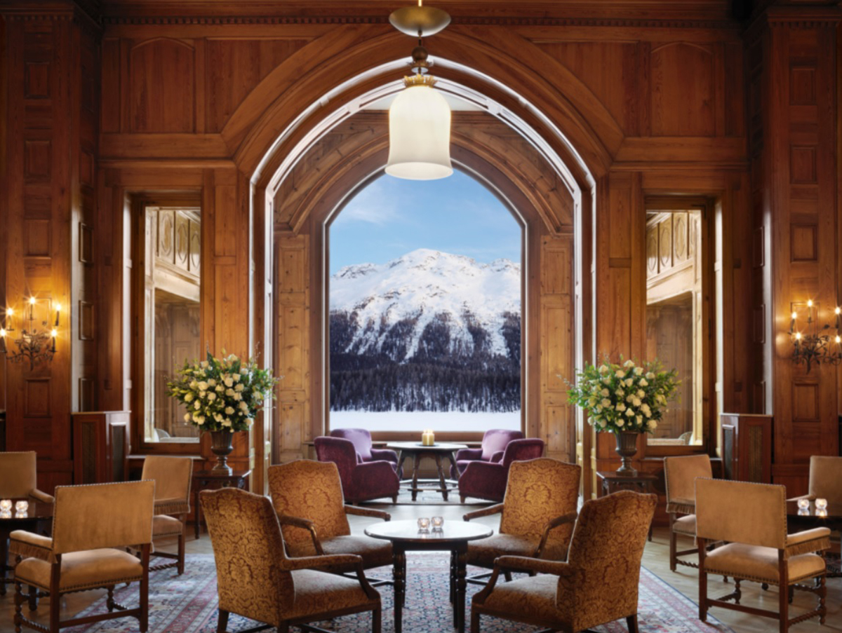 chairs in a lobby over looking a large window with a view of a snow covered mountain
