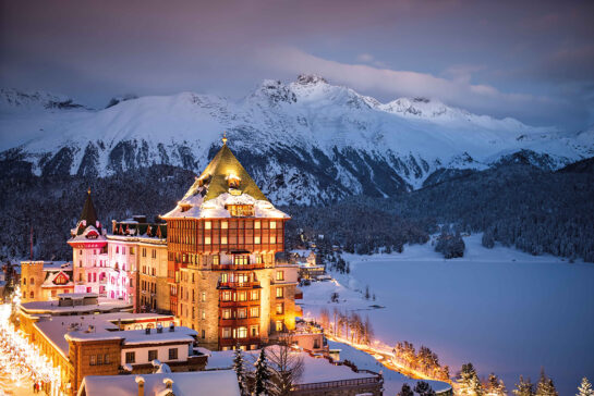 A lit up hotel in the mountains in winter
