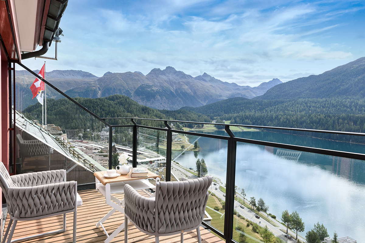 chairs on a terrace overlooking a mountain and lake
