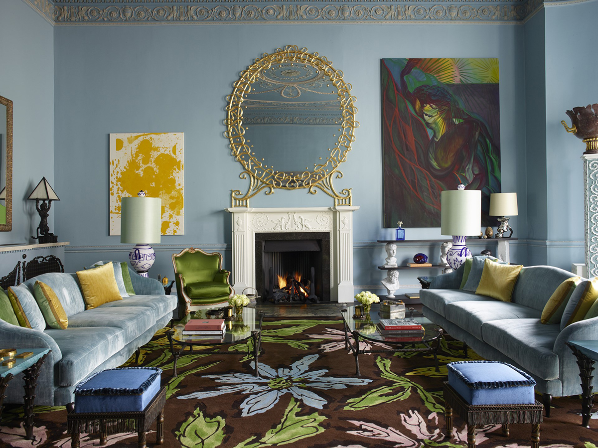 blue themed living room with velvet sofas and art on walls